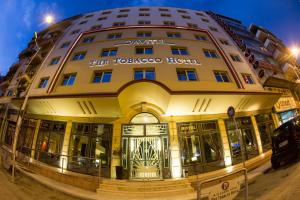 a large yellow building in front of a street at Davitel - Tobacco Hotel in Thessaloniki