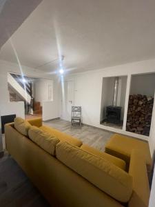 a living room with a yellow couch and a tv at Casa da Barragem Montargil in Montargil