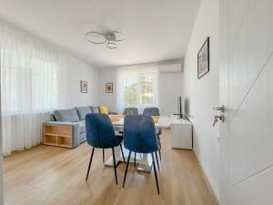 a living room with a table and blue chairs at Апартамент Tiana in Tsarevo