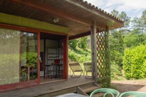 a screened in porch of a house with chairs at Bungalow Moulin Du Gournier in Malbosc