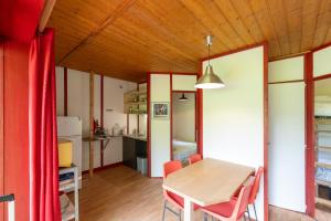 a kitchen and dining room with a table and chairs at Bungalow Moulin Du Gournier in Malbosc