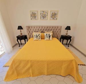 a yellow bed with two pillows on top of it at Seaside SunFlower in Quinta do Lago