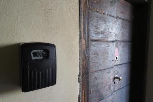 une porte en bois avec une boîte noire sur un mur dans l'établissement PrimoPiano - Mercato, à Milan