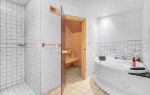 a white bathroom with a tub and a toilet at Three-Bedroom Holiday Home In Ulfborg in Ulfborg