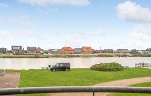 a car parked on the grass next to a river at Three-Bedroom Holiday Home In Ulfborg in Ulfborg +24 photos