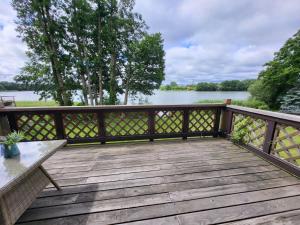 a wooden deck with a bench and a view of a lake at Apartament nad jeziorem Zamkowym in Wałcz