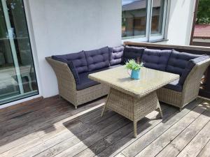 a patio with a couch and a table on a deck at Apartament nad jeziorem Zamkowym in Wałcz