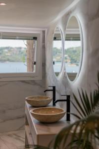 two sinks on a counter in a room with two windows at Para Thin Alos Skiathos in Skiathos +19 photos