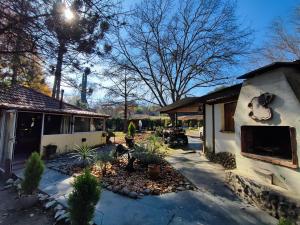 Ein Mann steht in einem Garten neben einem Haus. in der Unterkunft Casa del arroyo in Villa General Belgrano