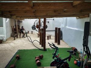 a gym with exercise equipment and a woman in the background at AVO Boutique Hotel in Dikoni