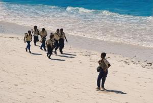 a group of people walking on the beach at AVO Boutique Hotel in Dikoni