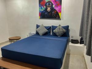a bedroom with a blue bed with a painting on the wall at AVO Boutique Hotel in Dikoni