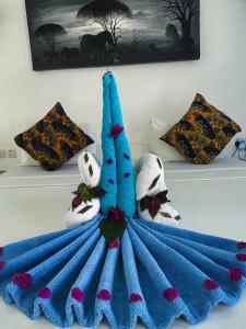 a blue blanket on a bed with two stuffed animals at AVO Boutique Hotel in Dikoni