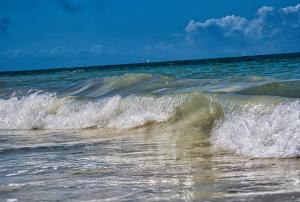 a small wave in the ocean on the beach at AVO Boutique Hotel in Dikoni