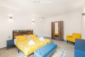 a bedroom with a yellow bed and a yellow chair at Pietra Futura, TerreMarine in Pignone