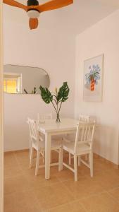 een witte eettafel met witte stoelen en een plant bij La Marea Baja in Puertito de Güímar +19 foto's