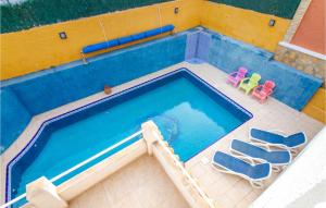 an overhead view of a swimming pool with two chairs at Amazing Home In Gran Alacant in Santa Pola