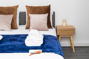 a bedroom with two beds with towels on them at Three Bedroom Apartment At Buonomo Stays Short Lets & Serviced Accommodation With Netflix & Games in London