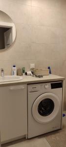 a washing machine and a sink in a bathroom at Cozy Kaunas apartment in Kaunas