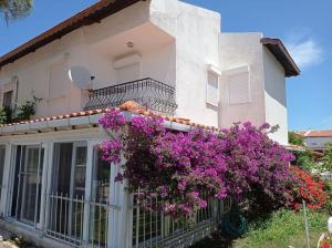 Una casa con flores moradas en el balcón. en Alacati villa, en Cesme