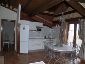 cocina con mesa y nevera blanca en Casa Rural El Cuartel, en Tierzo
