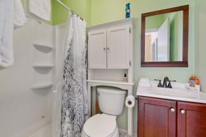 a bathroom with a toilet and a sink and a mirror at Ski Ya Later in Proctorsville