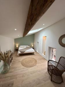 1 dormitorio grande con 1 cama, mesa y sillas en Au cœur des Caladons, en Lunel