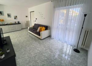 a living room with a couch and a large window at Apulian Apartment in Valenzano