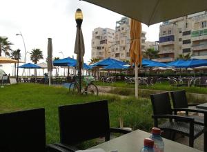 a group of tables and chairs with umbrellas and tables and chairs at Apartment 20m from Martil beach in Tétouan