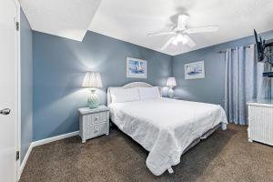 - une chambre bleue avec un lit et un ventilateur de plafond dans l'établissement Phoenix V Vacation Rental Condos, à Orange Beach
