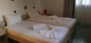 two beds in a room with white sheets and towels at Villa Maria in Kokkari
