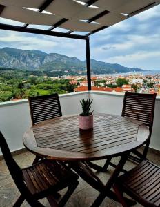 a wooden table with two chairs and a potted plant on a balcony at Villa Maria in Kokkari +7 photos