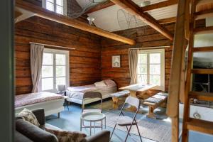 a living room with wooden walls and windows at Myllytupa in Merikaarto