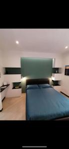 a bedroom with a blue bed and a green headboard at Casa Edera in Monterosso al Mare