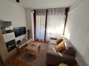 a living room with a couch and a tv at Apartman Tamara in Zadar +10 photos