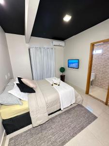 a bedroom with a large bed and a bathroom at Riacho Hotel in Brasília