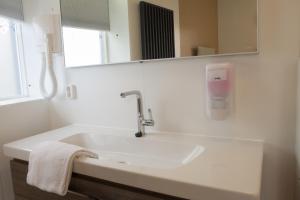 een witte badkamer met een wastafel en een spiegel bij Stadslogement Kingsize in Sneek