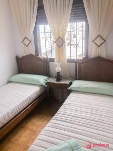 two beds sitting in a room with windows at La Finca in Oropesa del Mar