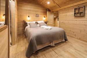 a bedroom with a bed in a wooden cabin at Les Chalets-H&ocirc;tel de la Croix-Fry in Manigod