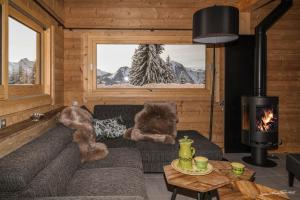 a living room with a couch and a fireplace at Les Chalets-H&ocirc;tel de la Croix-Fry in Manigod