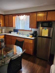 a kitchen with a stainless steel refrigerator and wooden cabinets at private upper 1 bd apartment in Buffalo