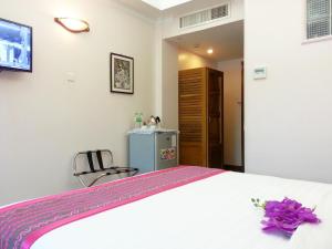 A bed or beds in a room at Grand Laurel Hotel