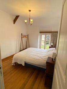 a bedroom with a white bed and a window at Maison L'Abeille in Saint-Plantaire