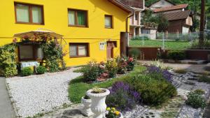 a yellow house with a garden in front of it at Pyramid Gardens in Visoko