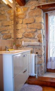 a kitchen with a sink and a stone wall at Gîte Gîtes de France 2/4 personnes à la Peyre in Saint-Frézal-dʼAlbuges