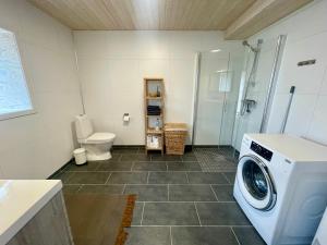 a bathroom with a washing machine and a toilet at Renovated barn with a view in Bjørnsand +29 photos