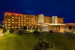 un bâtiment d'hôtel avec une pelouse devant lui dans l'établissement Hilton Garden Inn Rome Airport, à Fiumicino