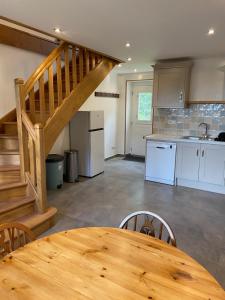 a kitchen with a wooden table and a wooden staircase at Maison L'Abeille in Saint-Plantaire