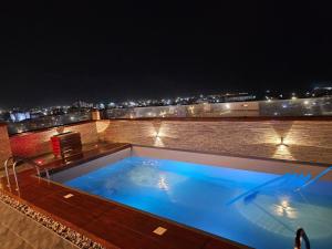 a swimming pool on top of a building at night at Mansah Plus Hotel and Apartments in Accra