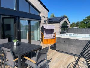 a patio with a table and chairs and a hot tub at My Baltic Sea - Ferienwohnungen im Ocean Hill in Scharbeutz